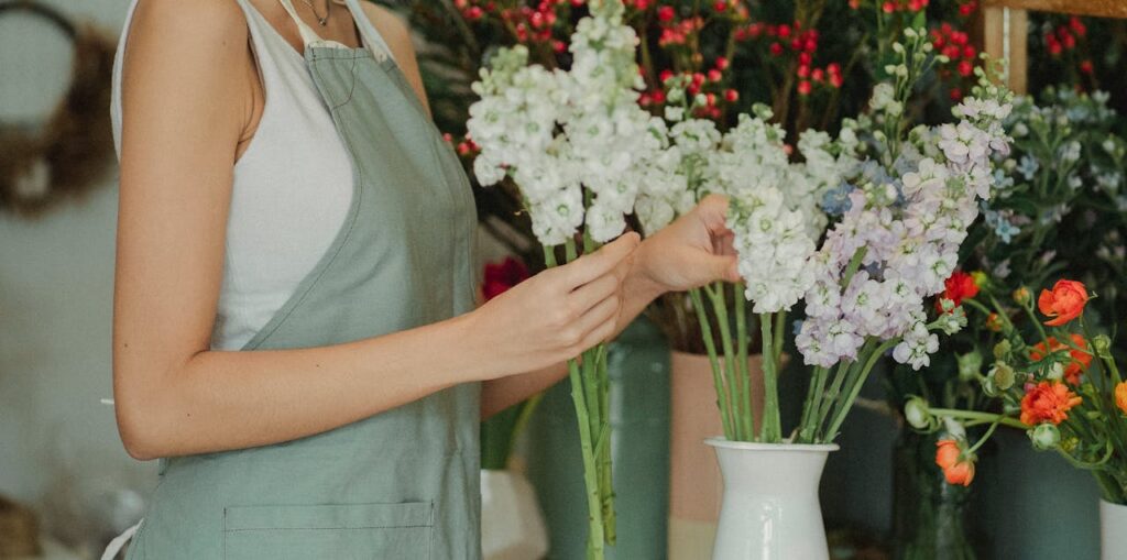 The Art of Drawing Readers In: Your attractive post title goes here Crop anonymous florist in apron standing near table with flowers in vases and choosing flowers for composition