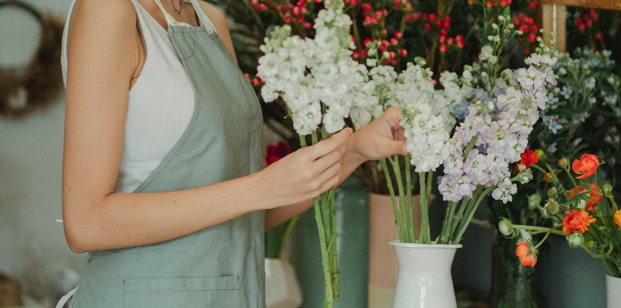 The Art of Drawing Readers In: Your attractive post title goes here Crop anonymous florist in apron standing near table with flowers in vases and choosing flowers for composition